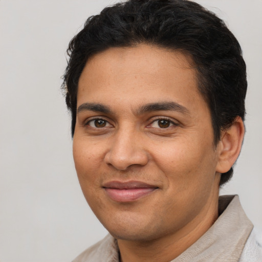 Joyful latino young-adult male with short  brown hair and brown eyes