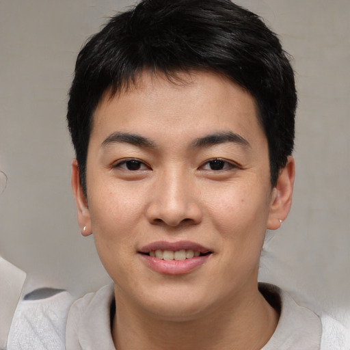 Joyful asian young-adult male with short  black hair and brown eyes