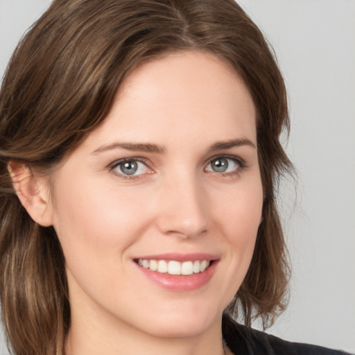 Joyful white young-adult female with medium  brown hair and grey eyes