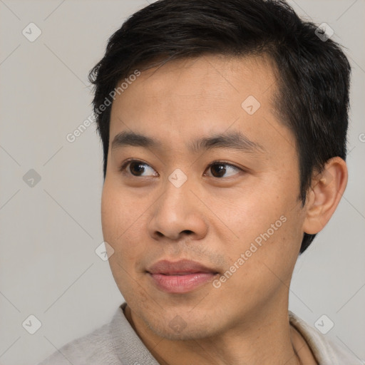 Joyful asian young-adult male with short  brown hair and brown eyes