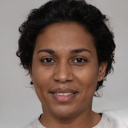 Joyful black adult female with short  black hair and brown eyes