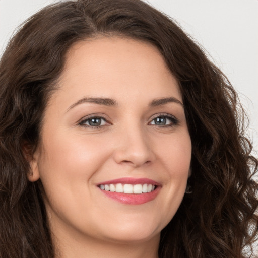 Joyful white young-adult female with long  brown hair and brown eyes