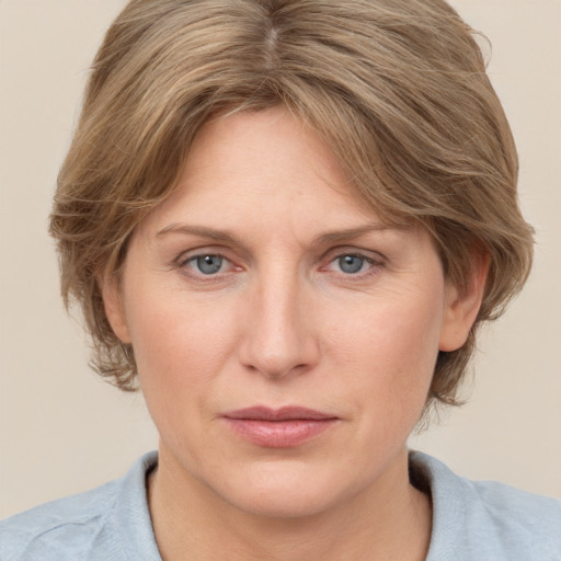 Joyful white adult female with medium  brown hair and blue eyes