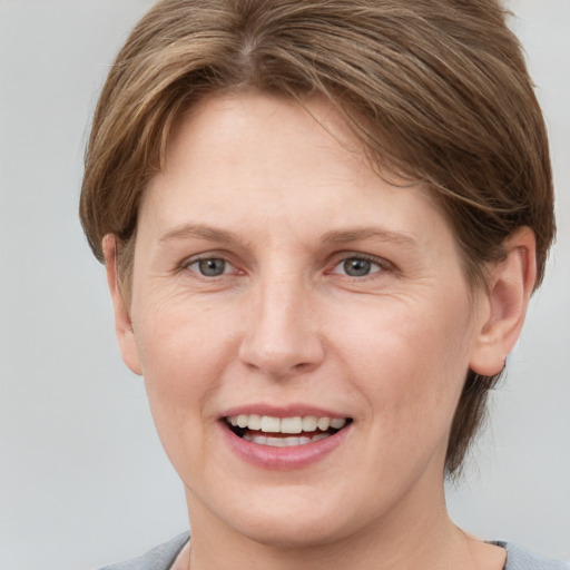 Joyful white young-adult female with short  brown hair and grey eyes