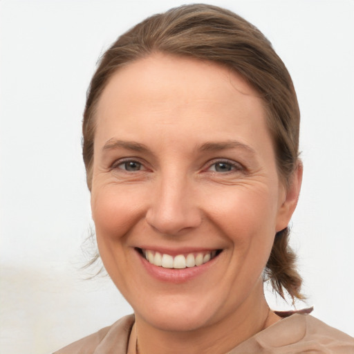 Joyful white adult female with medium  brown hair and grey eyes