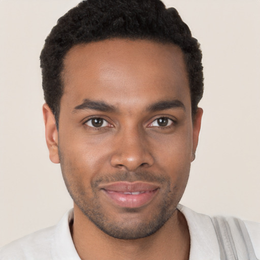 Joyful black young-adult male with short  brown hair and brown eyes