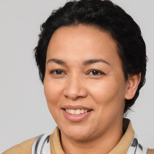 Joyful latino adult female with medium  brown hair and brown eyes