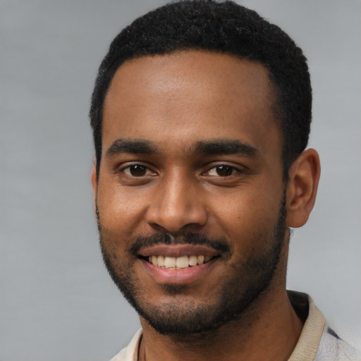 Joyful black young-adult male with short  black hair and brown eyes