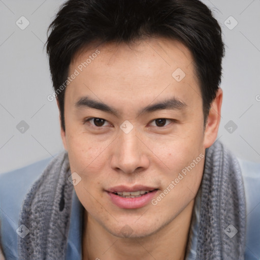 Joyful asian young-adult male with short  brown hair and brown eyes