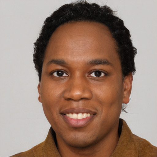 Joyful black young-adult male with short  black hair and brown eyes