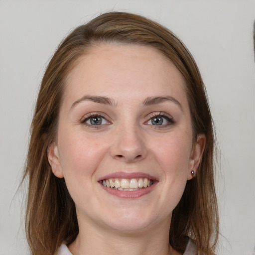 Joyful white young-adult female with medium  brown hair and grey eyes