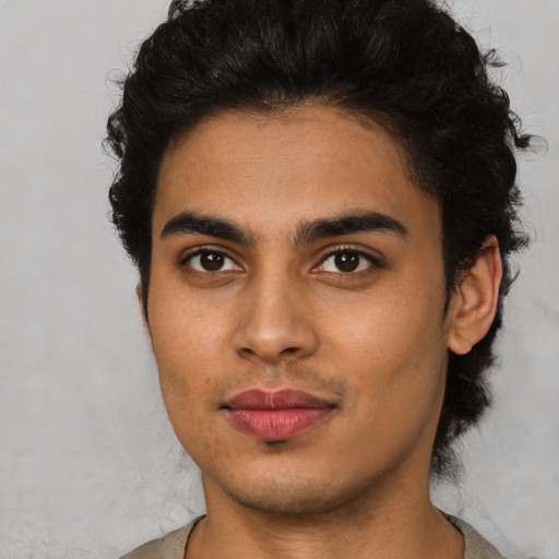 Joyful latino young-adult male with short  brown hair and brown eyes