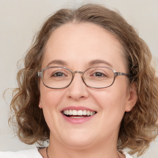 Joyful white adult female with medium  brown hair and green eyes