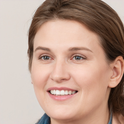 Joyful white young-adult female with medium  brown hair and blue eyes