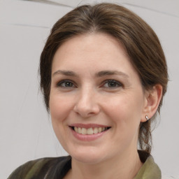 Joyful white young-adult female with medium  brown hair and grey eyes