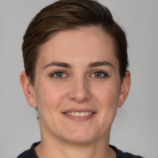 Joyful white young-adult female with short  brown hair and grey eyes