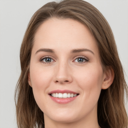 Joyful white young-adult female with long  brown hair and grey eyes