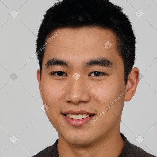 Joyful asian young-adult male with short  black hair and brown eyes