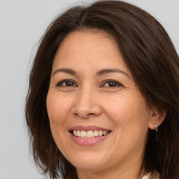 Joyful white adult female with long  brown hair and brown eyes