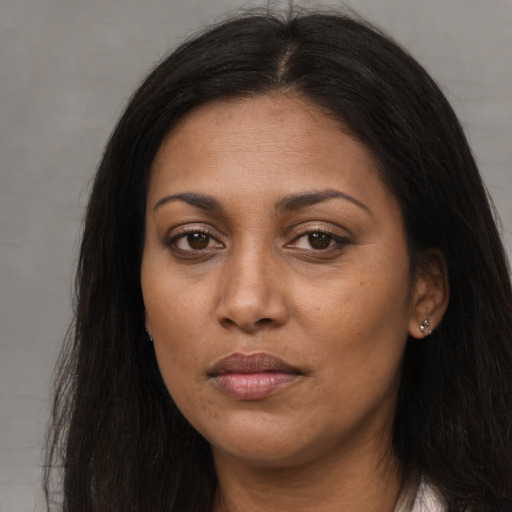Joyful black young-adult female with long  brown hair and brown eyes