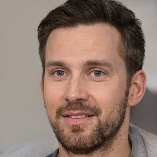 Joyful white adult male with short  brown hair and brown eyes