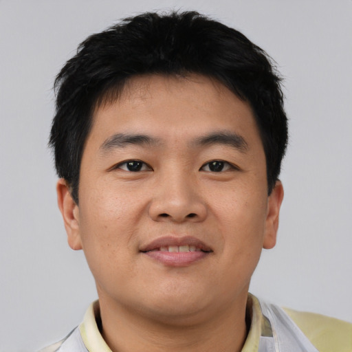 Joyful asian young-adult male with short  black hair and brown eyes