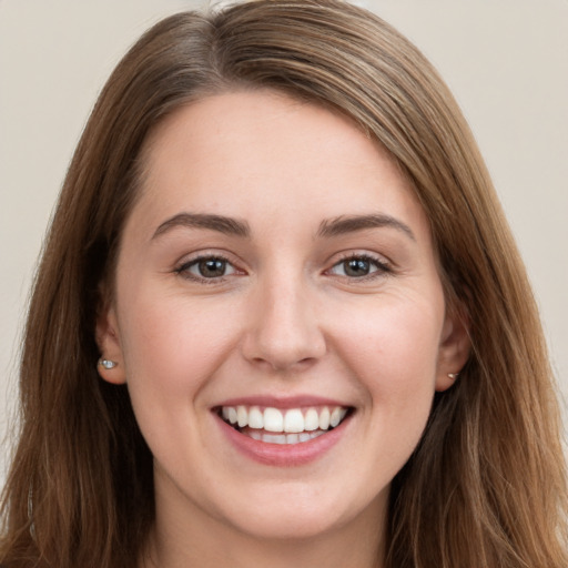 Joyful white young-adult female with long  brown hair and grey eyes