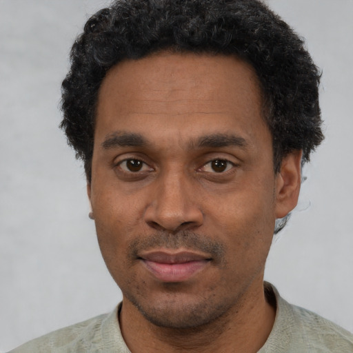 Joyful black adult male with short  black hair and brown eyes