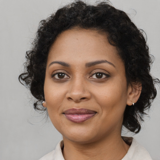 Joyful black young-adult female with medium  brown hair and brown eyes