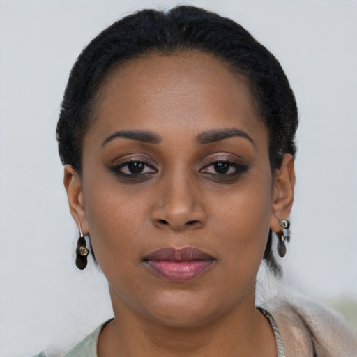 Joyful black young-adult female with short  black hair and brown eyes