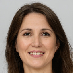 Joyful white adult female with long  brown hair and brown eyes