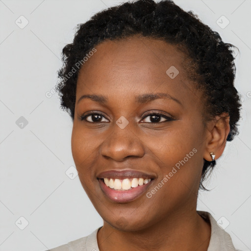 Joyful black young-adult female with short  brown hair and brown eyes