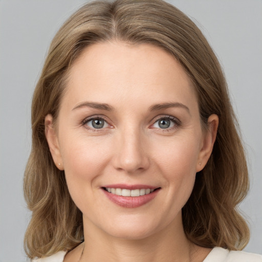 Joyful white young-adult female with medium  brown hair and grey eyes