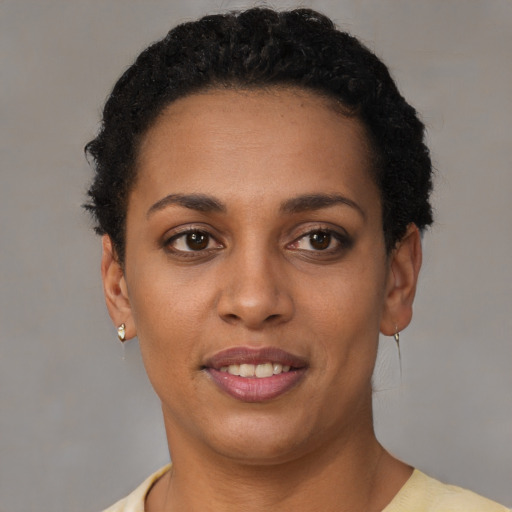 Joyful black young-adult female with short  black hair and brown eyes