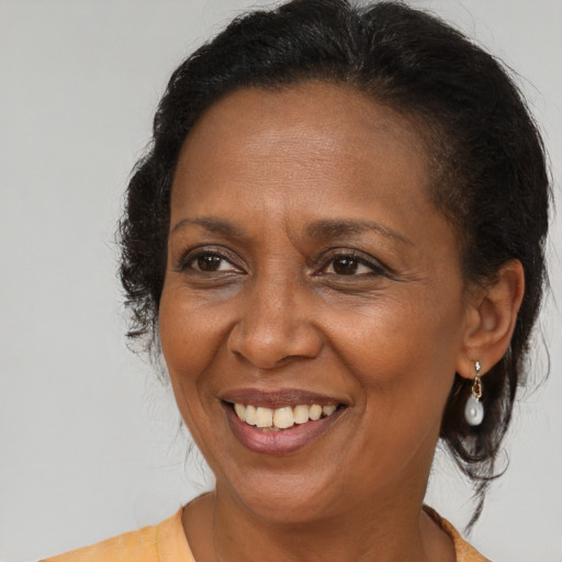 Joyful black adult female with medium  brown hair and brown eyes