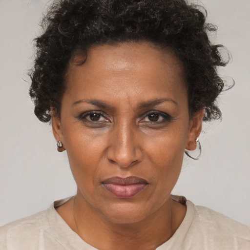 Joyful black adult female with short  brown hair and brown eyes