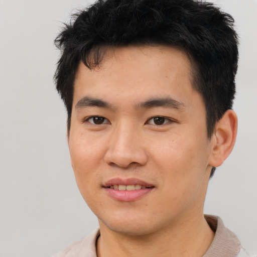 Joyful asian young-adult male with short  brown hair and brown eyes