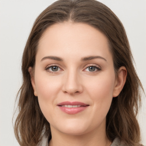 Joyful white young-adult female with long  brown hair and grey eyes