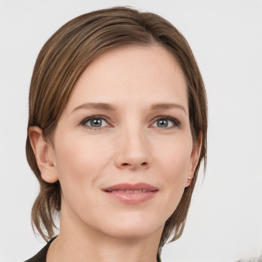 Joyful white young-adult female with medium  brown hair and grey eyes