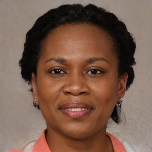 Joyful black young-adult female with short  black hair and brown eyes