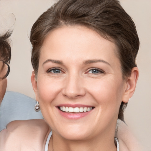 Joyful white young-adult female with medium  brown hair and grey eyes