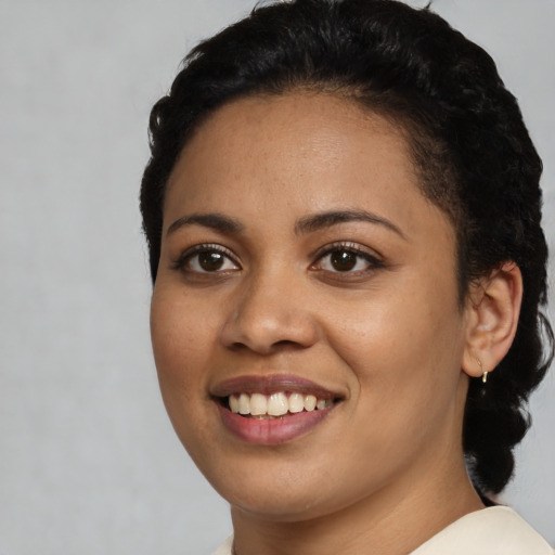 Joyful latino young-adult female with short  black hair and brown eyes