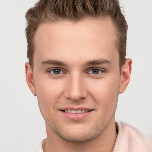 Joyful white young-adult male with short  brown hair and grey eyes