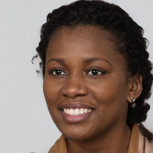 Joyful black young-adult female with long  brown hair and brown eyes
