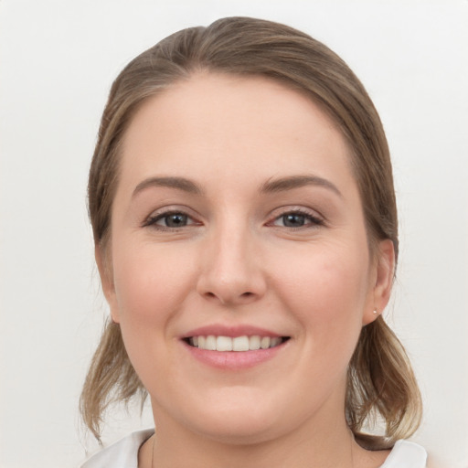 Joyful white young-adult female with medium  brown hair and grey eyes