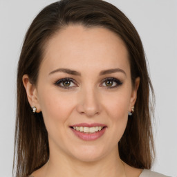 Joyful white young-adult female with long  brown hair and green eyes