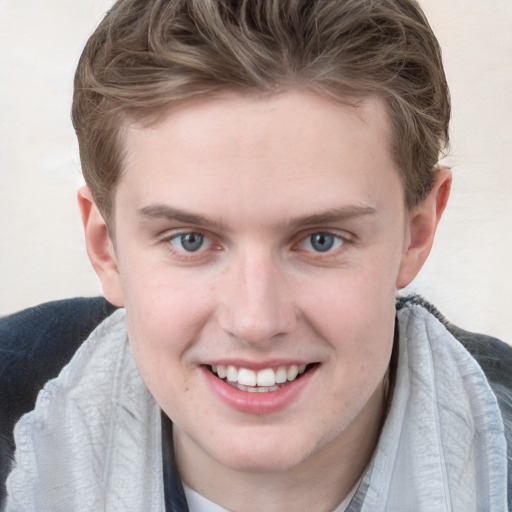 Joyful white young-adult male with short  brown hair and blue eyes