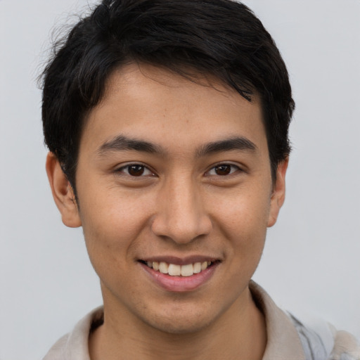 Joyful latino young-adult male with short  brown hair and brown eyes