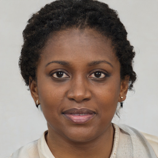 Joyful black young-adult female with short  brown hair and brown eyes