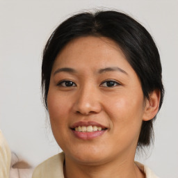 Joyful asian young-adult female with medium  brown hair and brown eyes